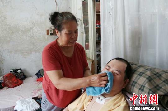 每次喂完食物后，梁青蘭都要仔細(xì)地幫兒子清理干凈?！∩忻鱾b 攝