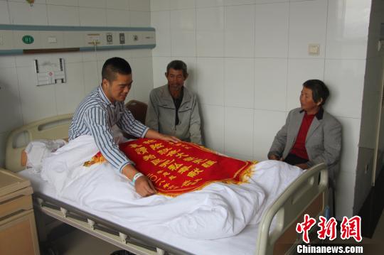 被救的李忠起、張總鳳夫婦看望受傷后的李運(yùn)飛?！⊥粲?攝