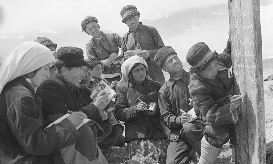 1960年6月，新疆慕士塔格峰下，大人們在小學生幫助下學習文化。新華社記者武純展攝